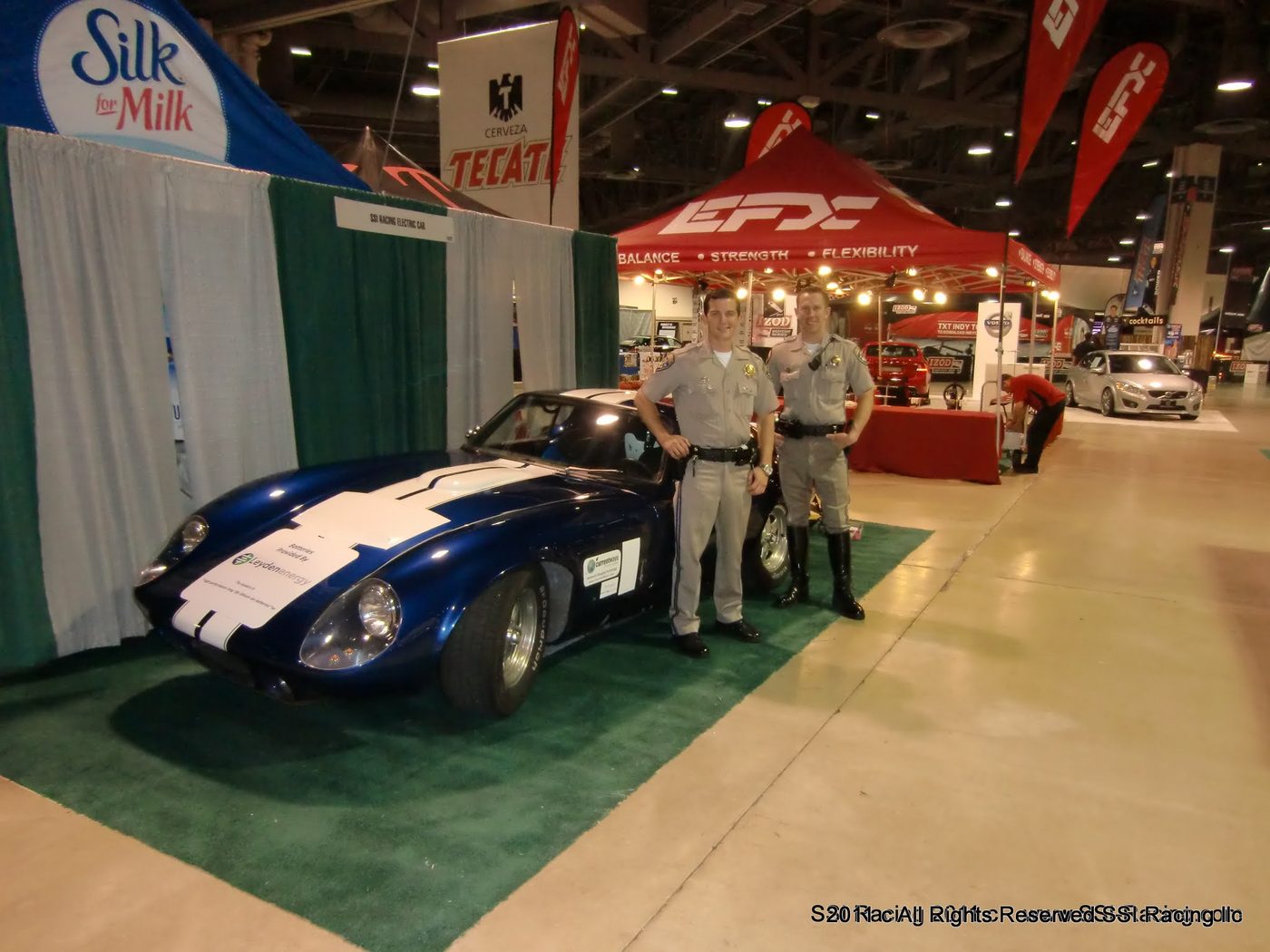 Two police officers standing by the car on green carpet at the Long Beach Grand Prix