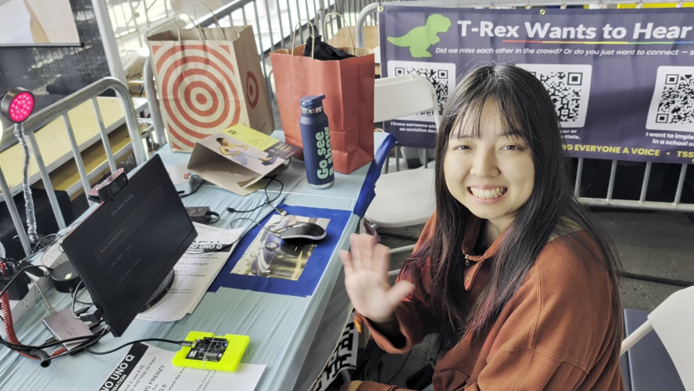 T-Rex's daughter Nova smiling and waving at the eye-tracking station, next to the UNO Q in its yellow case