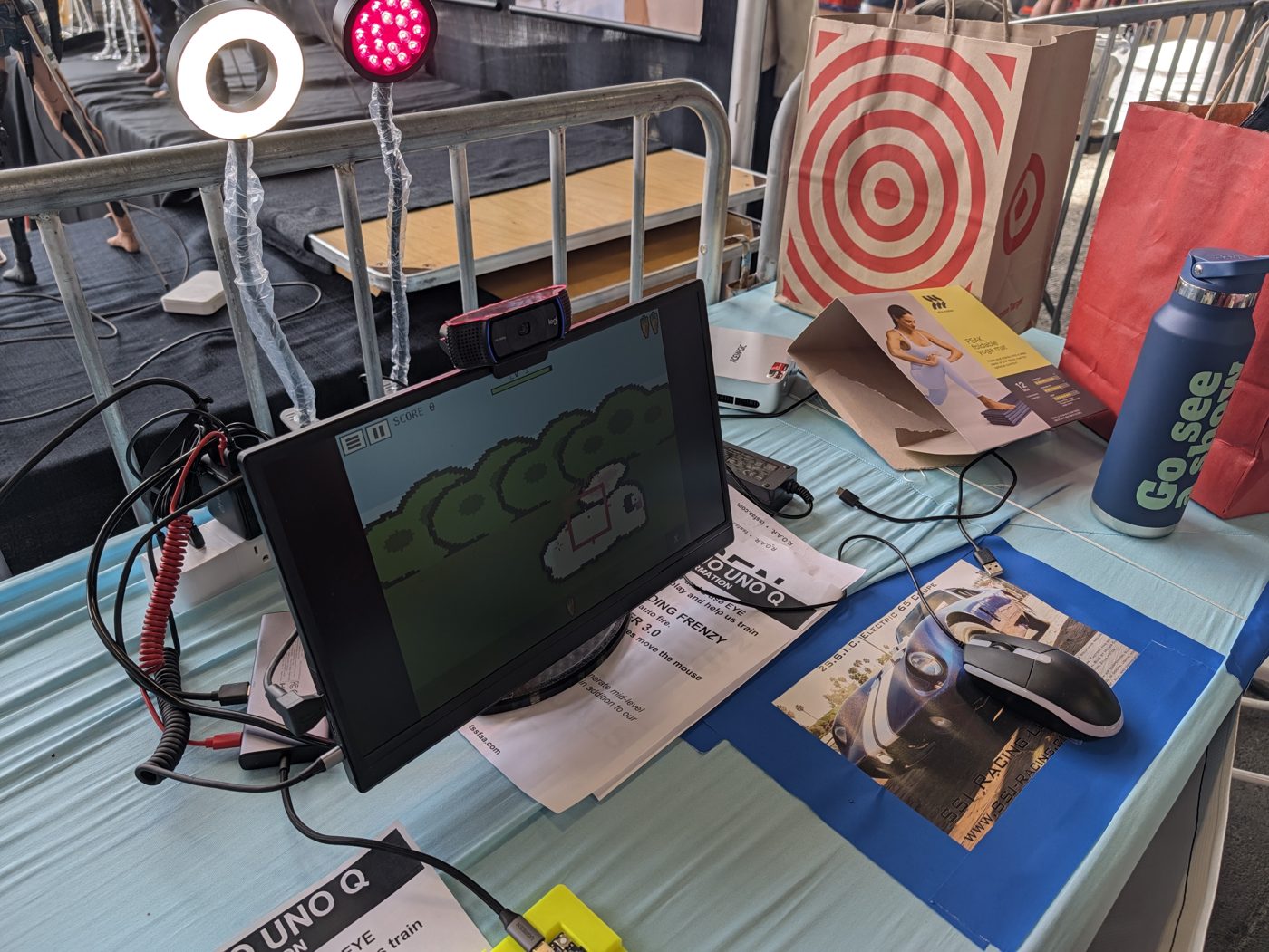The eye-tracking station: a ring light and a red LED lamp above the screen running Bunny Feeding Frenzy, with a webcam on top